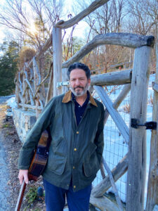 John Pizzarelli standing outside with guitar