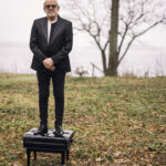 Bob James standing on a piano stool in a field